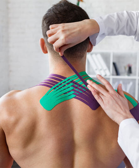 Physiotherapist applying kinesio tape to patient's back
